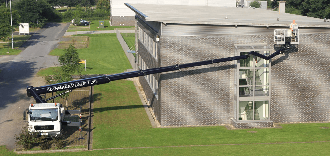 Ruthmann STEIGER T 285 truck-mounted platform reaching across a building